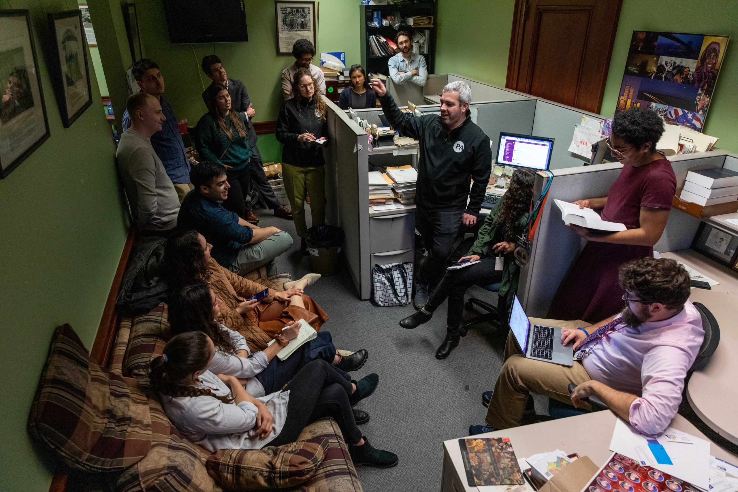 Spotlight PA staffers gather in a dimly lit office.