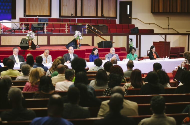 Candidates for Philadelphia Mayor sit on a panel as part of a community event at a church.