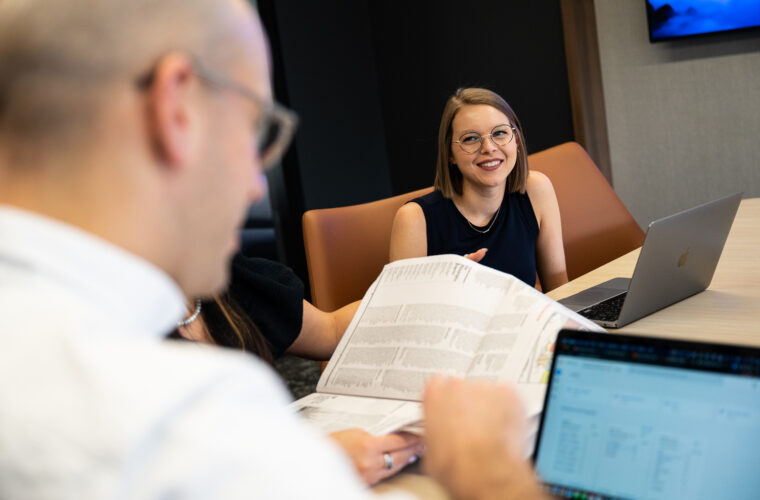 A woman laughs while sitting at a conference table