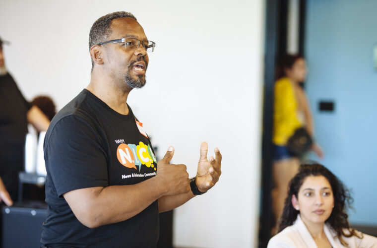 A man speaks wearing a N.I.C.E. T-shirt