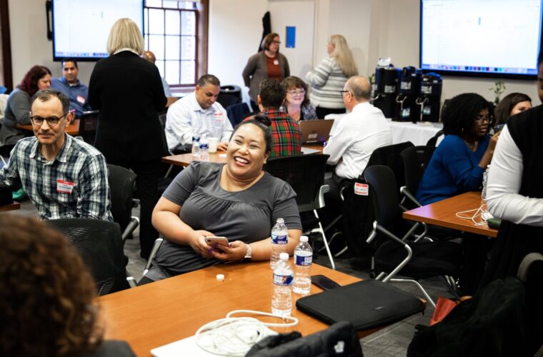 News professionals sit around tables preparing for a Table Stakes session