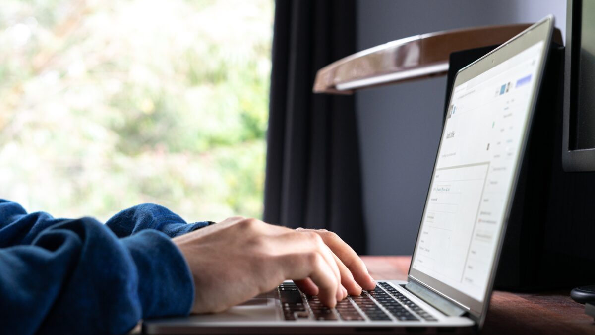 Hands typing on a laptop keyboard