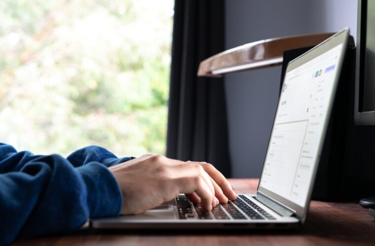 Hands typing on a laptop keyboard