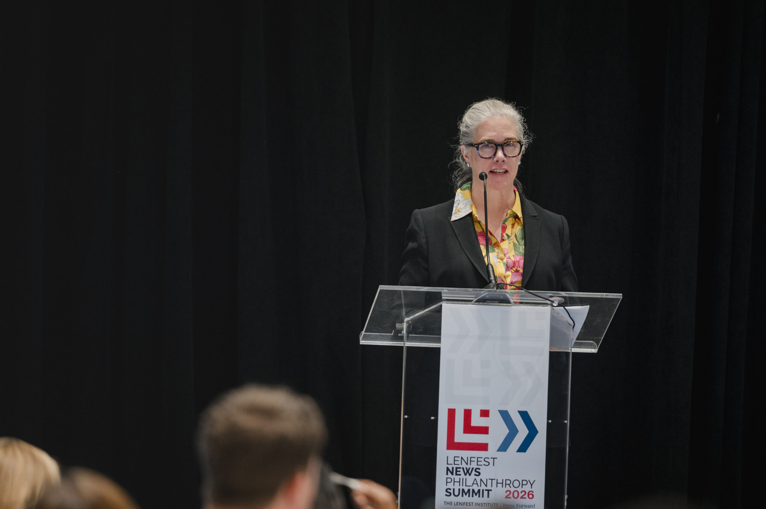 Annie McCain speaking at a podium at the 2026 Lenfest News Philanthropy Summit